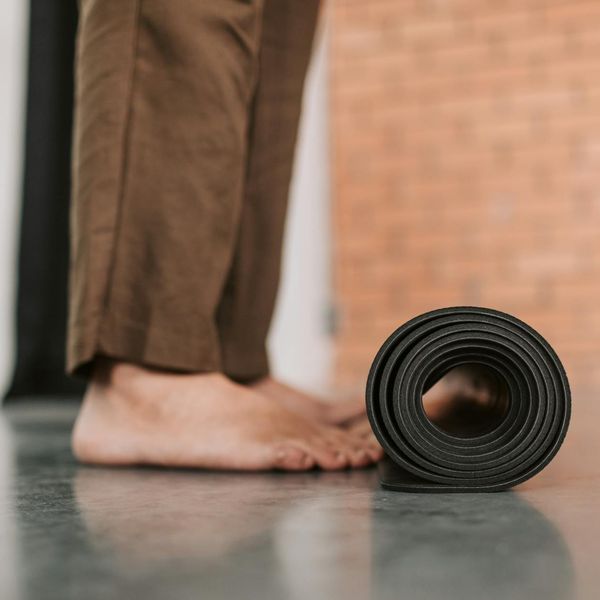 A neatly rolled yoga mat next to a water bottle symbolizing preparation for practice.